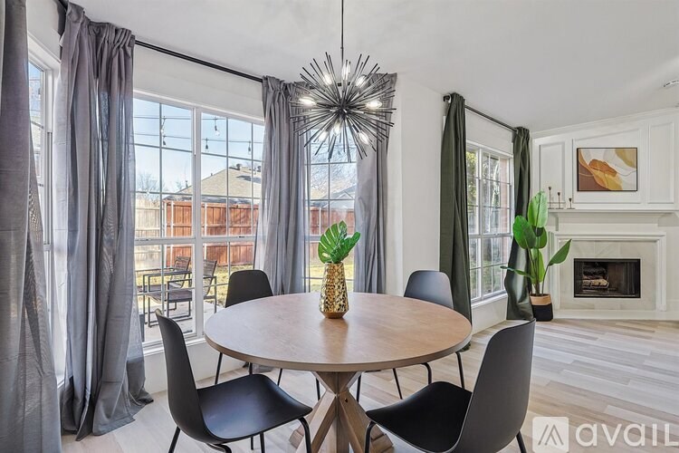 A modern dining room with a round table and chairs.