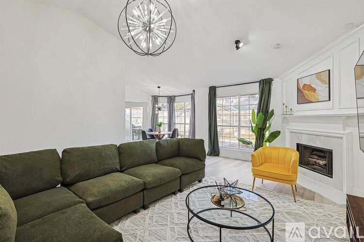 A living room with a green couch and a yellow chair.