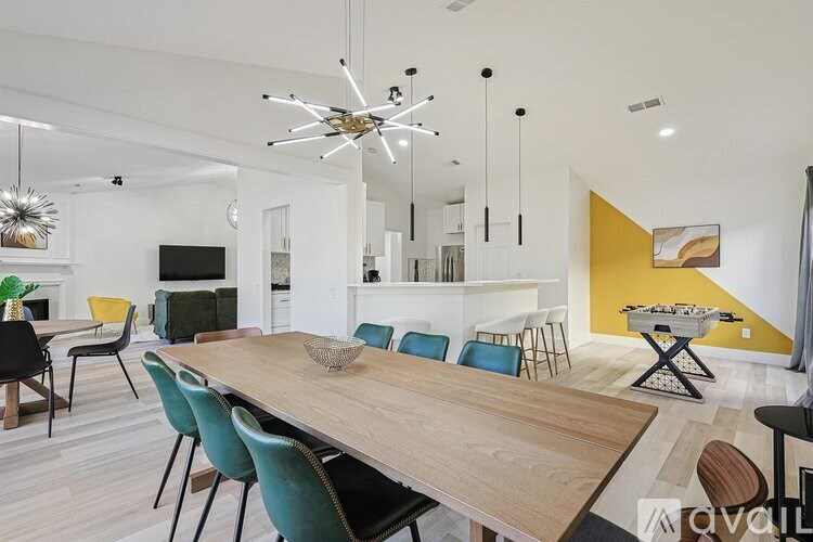 A modern dining room with a long wooden table and blue chairs.