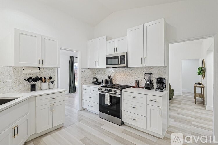 A kitchen with white cabinets and a black stove top oven.