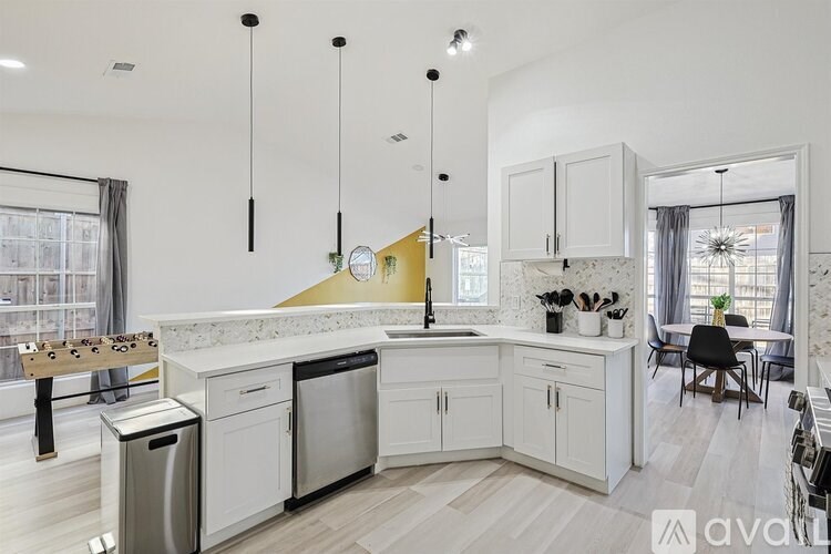 A modern kitchen with white cabinets and a yellow backsplash.