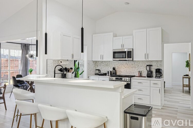 A modern kitchen with white cabinets and a central island.