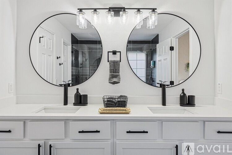 A bathroom with two sinks and two mirrors above them.
