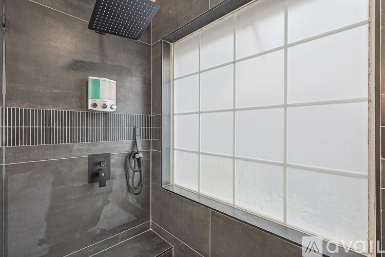 A bathroom with a shower and a window.