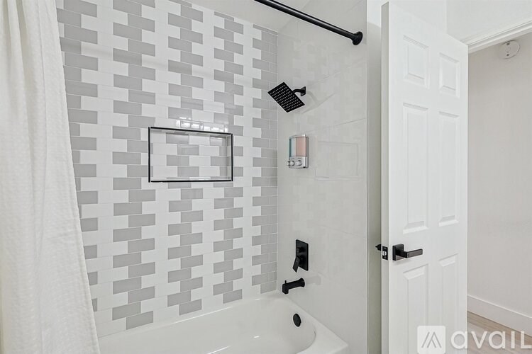 A white bathroom with a shower and a white door.