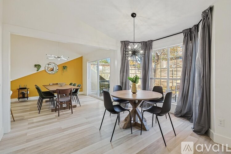 A dining room with a round table and chairs.