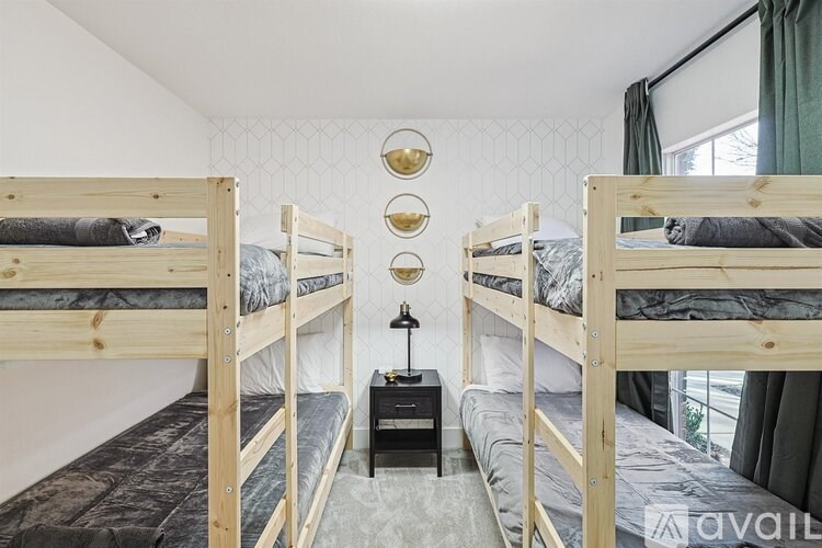 Three bunk beds in a room with a grey carpet.