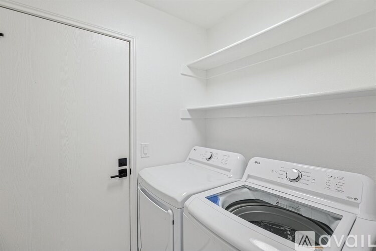A white washing machine and dryer in a small laundry room.