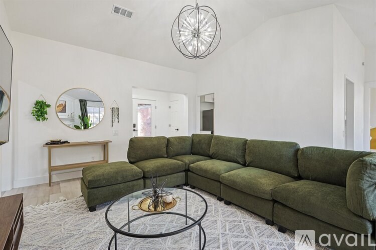 A living room with a green couch and a coffee table.