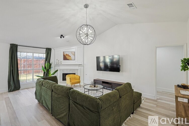 A living room with a green couch and a fireplace.