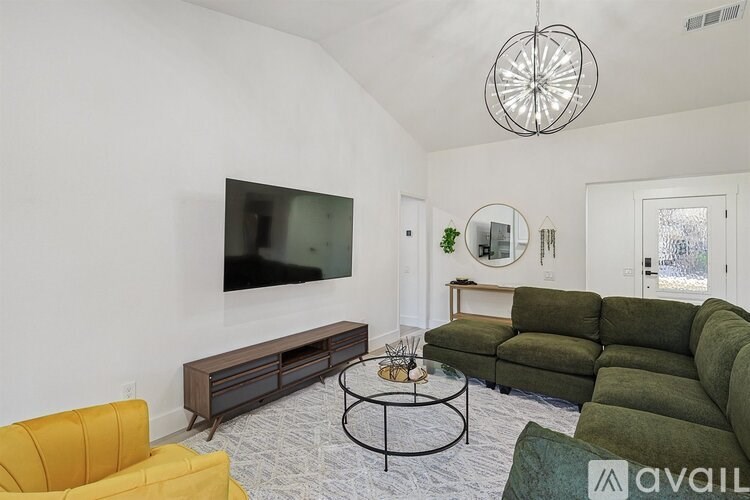 A living room with a green couch and a yellow chair.