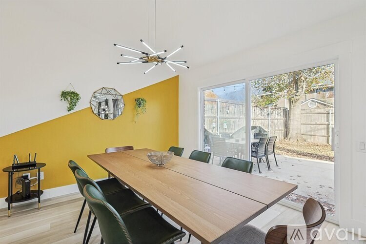 A dining room with a wooden table and green chairs.
