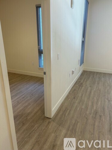A room with wooden flooring and a window.