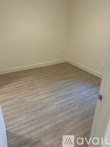 A room with wooden flooring and a white door.