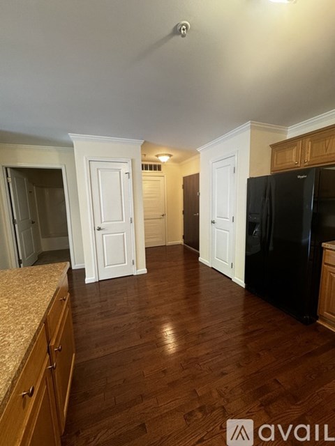 A kitchen with wooden floors and white walls.