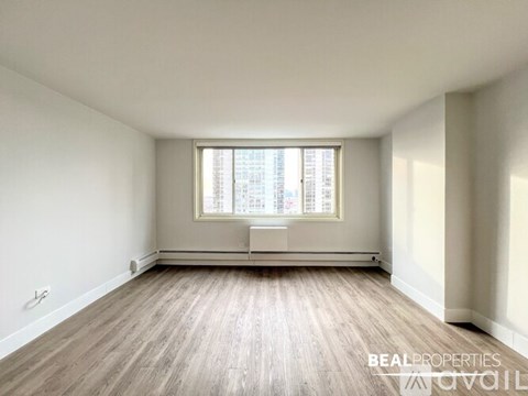 A spacious room with wooden floors and large windows is available for rent.