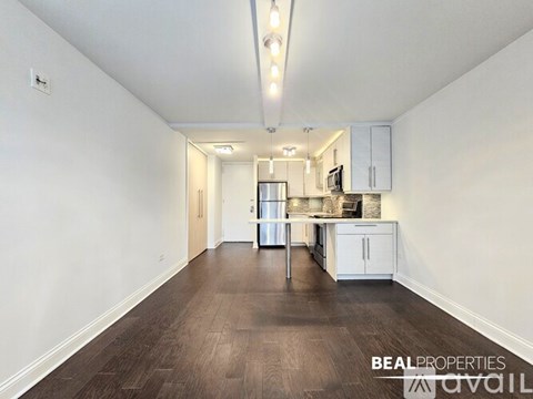 A spacious kitchen with white cabinets and a refrigerator is visible in the image.