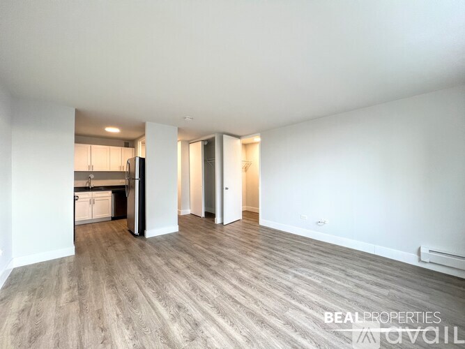 A white bathroom with a walk in shower and a white towel rack.