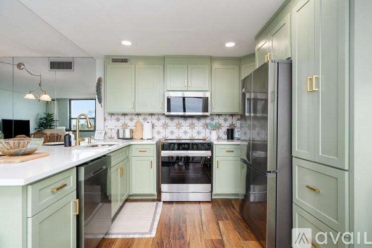 A kitchen with green cabinets and a white countertop.