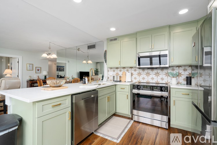 A kitchen with green cabinets and a white countertop.