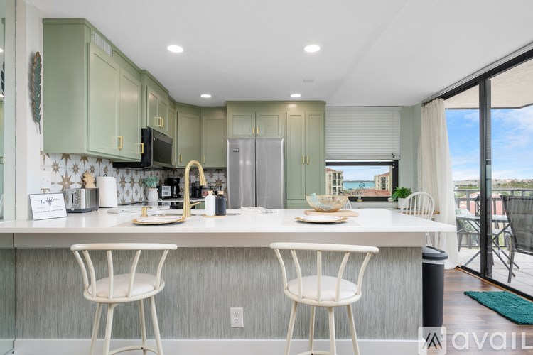 A kitchen with green cabinets and a white countertop.