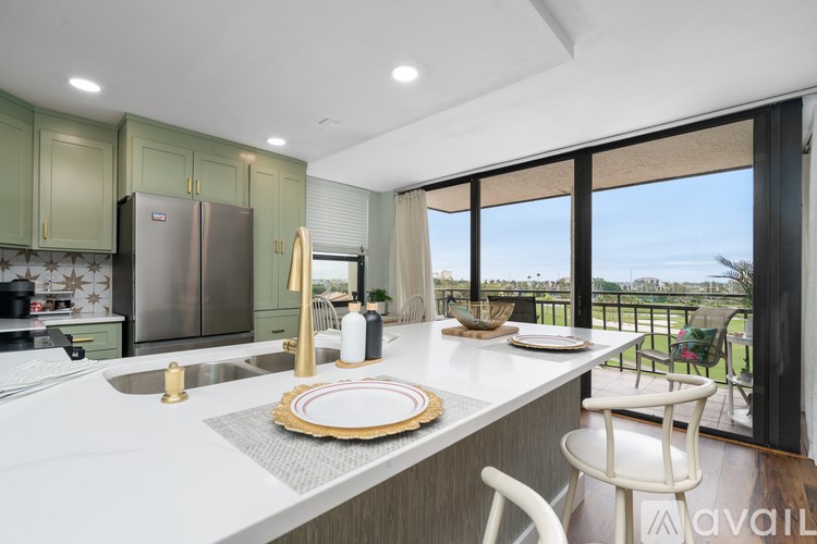 A kitchen with a table set for two and a view of the outside.
