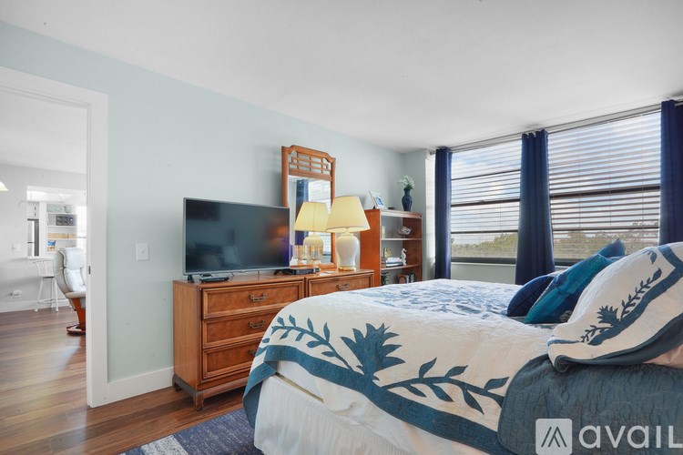 A bedroom with a bed, a dresser, and a television.
