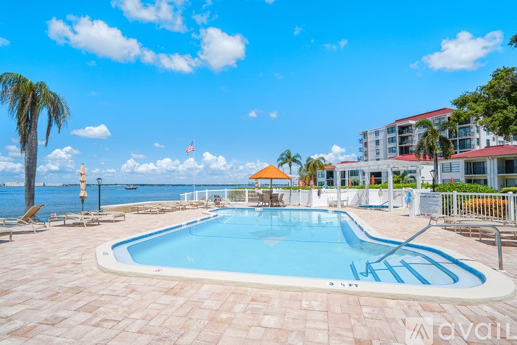 A large outdoor swimming pool with a sun lounger and umbrella.