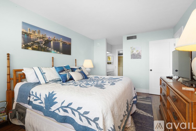 A bedroom with a bed, nightstand, and lamp.