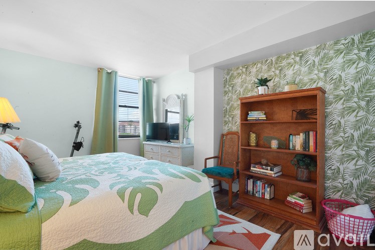 A bedroom with a bed, a bookshelf, and a window.