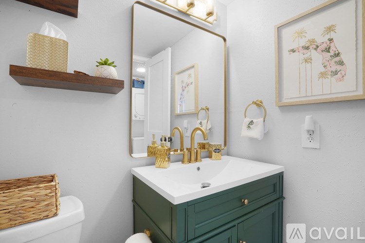 A bathroom with a green vanity and a mirror.