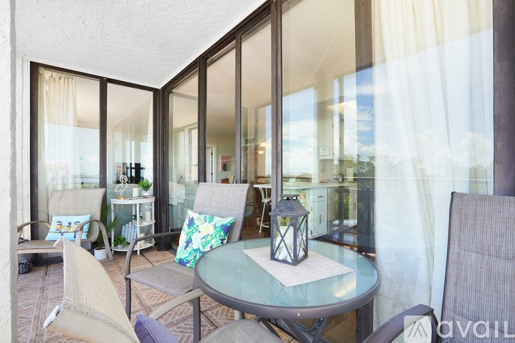 A table with a lantern on it sits in the middle of a patio.