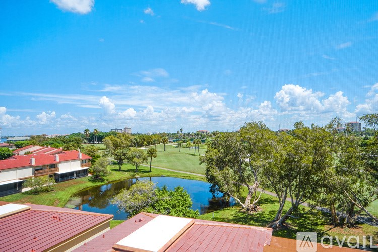 A view of a residential area with a pond and trees.