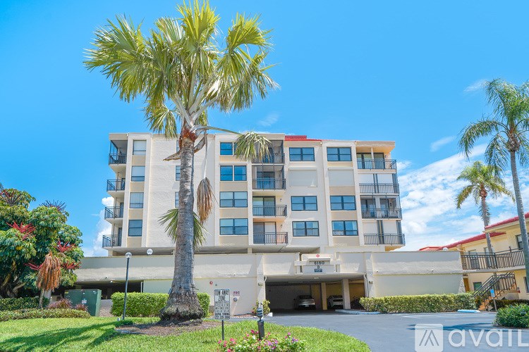 A tall building with a palm tree in front of it.