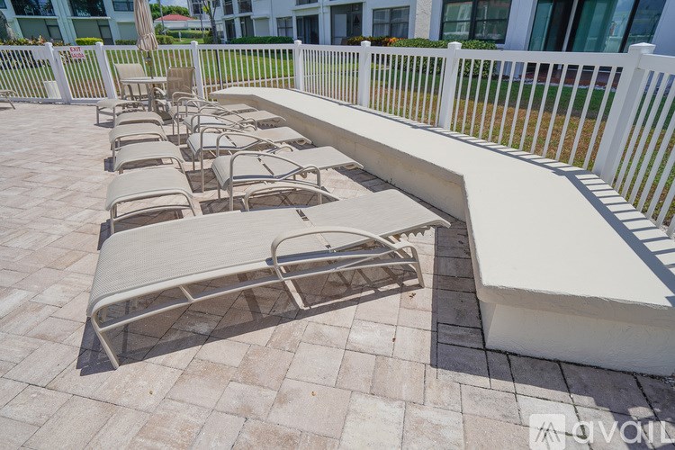 A row of sun loungers are on a patio.