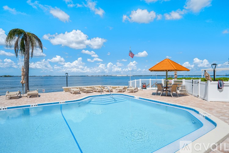 A pool with a blue water and a yellow umbrella.