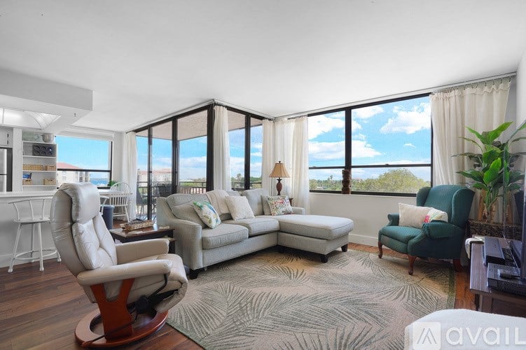 A living room with a large window and a view of the sky.