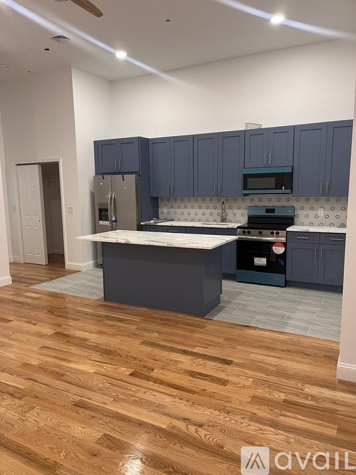 A kitchen with wooden floors and blue cabinets.