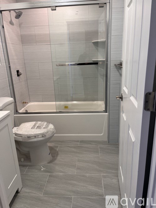 A white toilet sits next to a walk-in shower in a bathroom.