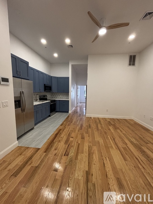 A kitchen with wooden floors and a refrigerator.