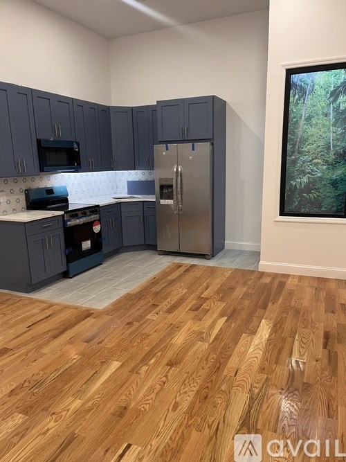 A kitchen with wooden floors and a refrigerator.
