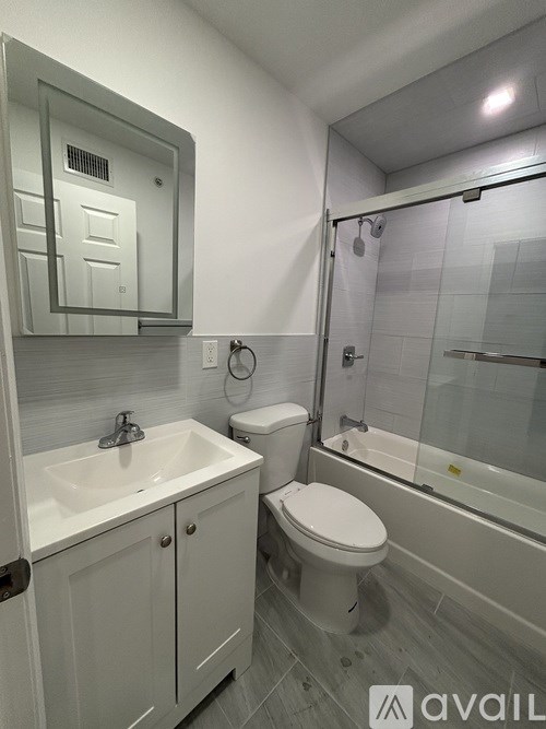 A white washing machine is in a cabinet next to a white door.