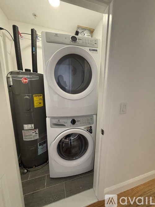 A stacked washer and dryer in a small laundry room.