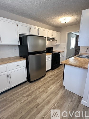 A kitchen with white cabinets and a wooden countertop.