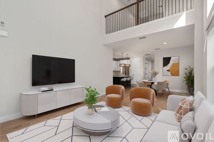 A living room with a white sofa, a black TV, and a coffee table with a plant on it.