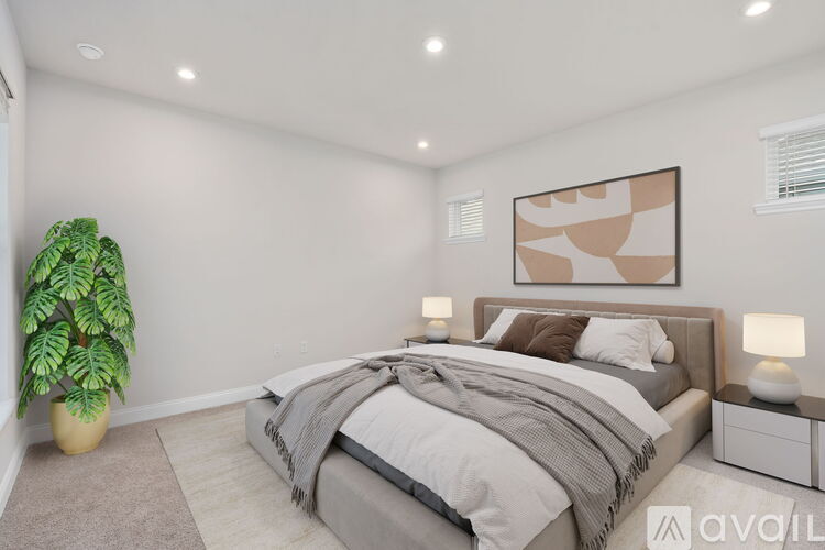 A well-lit bedroom with a large bed and a potted plant.
