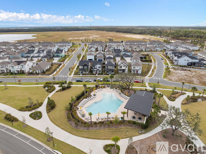 A bird's eye view of a residential area with a swimming pool and houses.