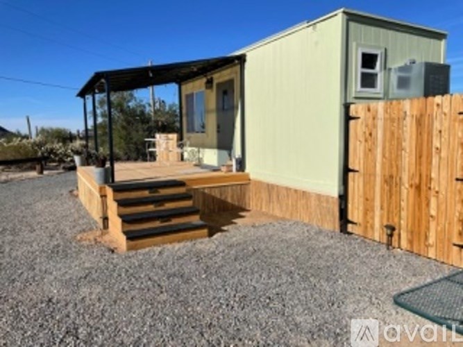 A small house with a wooden fence in front.
