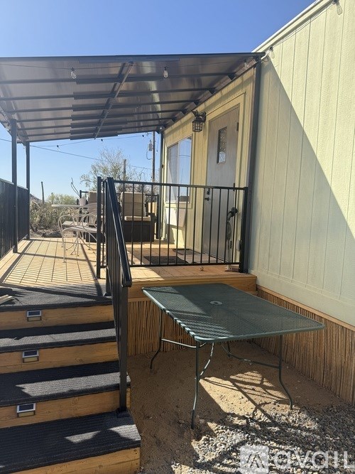 A patio with a table and chairs and a metal railing.
