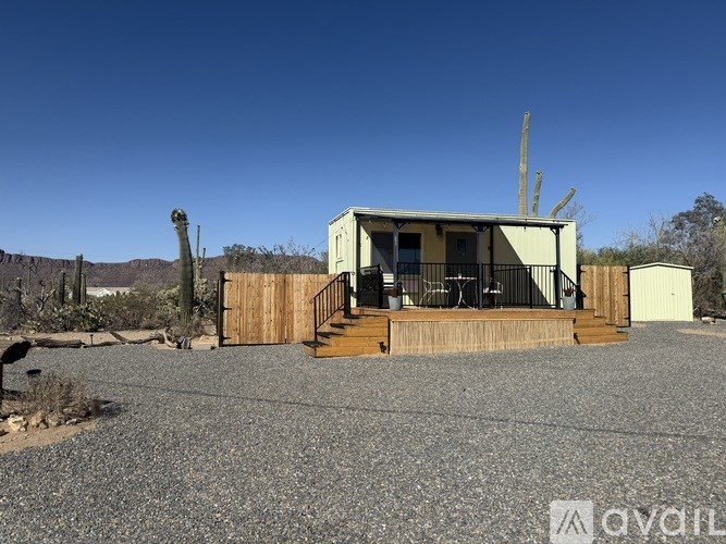 A house with a deck and a cactus in the background.